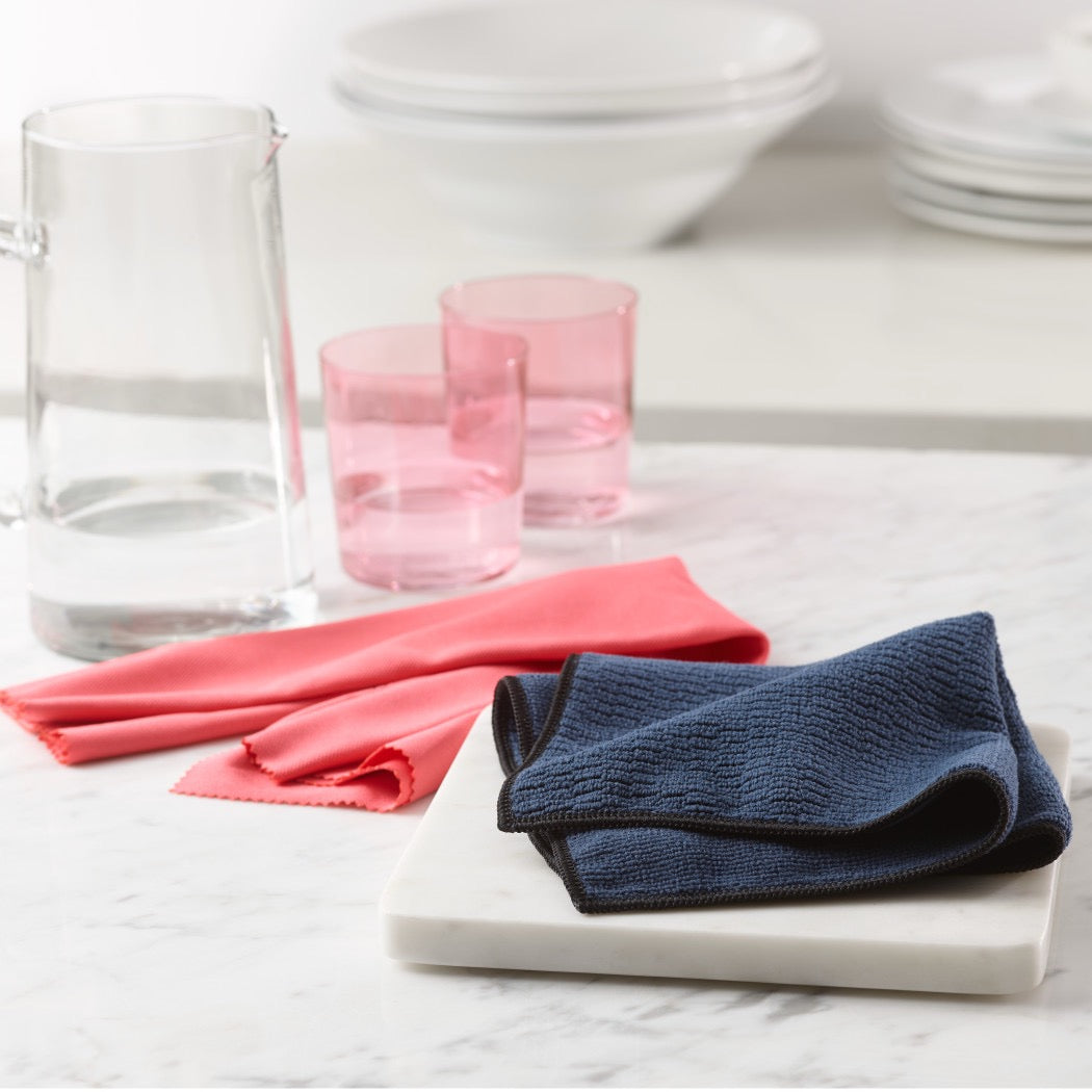 Granite & Stone cloth on counter with polishing cloth nearby with glasses of water and a pitcher in the background