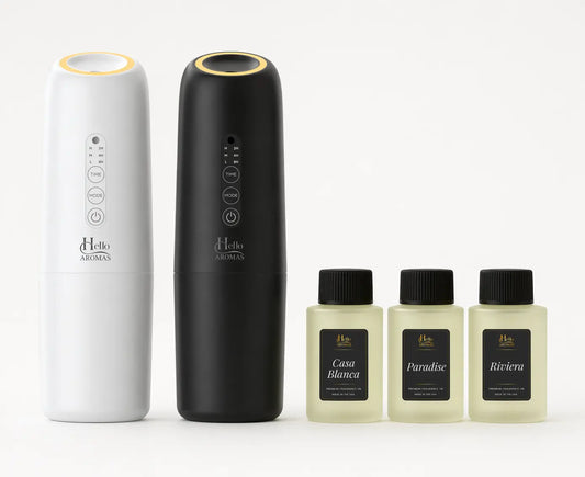 White and black hello aromas oasis plug-in scent diffusers with gold tops and three fragrance oil bottles labeled casa blanca paradise and riviera