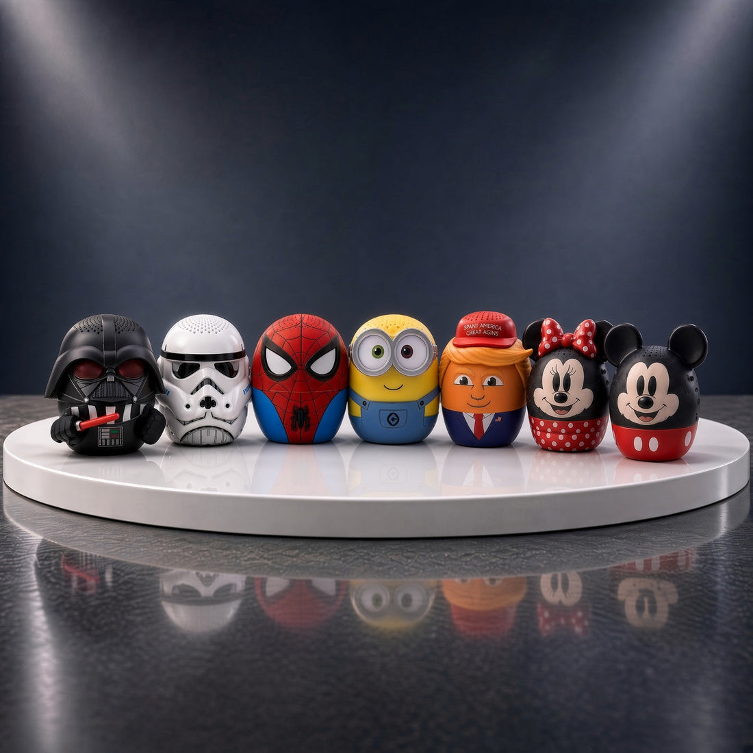 Seven Bitty Boomers mini Bluetooth speakers lined up on a round stage: Darth Vader, Stormtrooper, Spider-Man, Bob the Minion, Donald Trump, Minnie Mouse and Mickey Mouse
