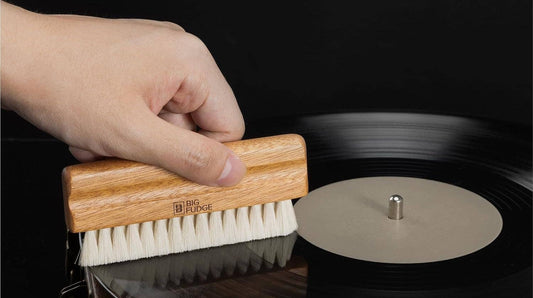 Hand dry-brushing a vinyl record with the Big Fudge Sapele wood goat hair brush from the Collector's Edition Record Cleaning Brush Kit