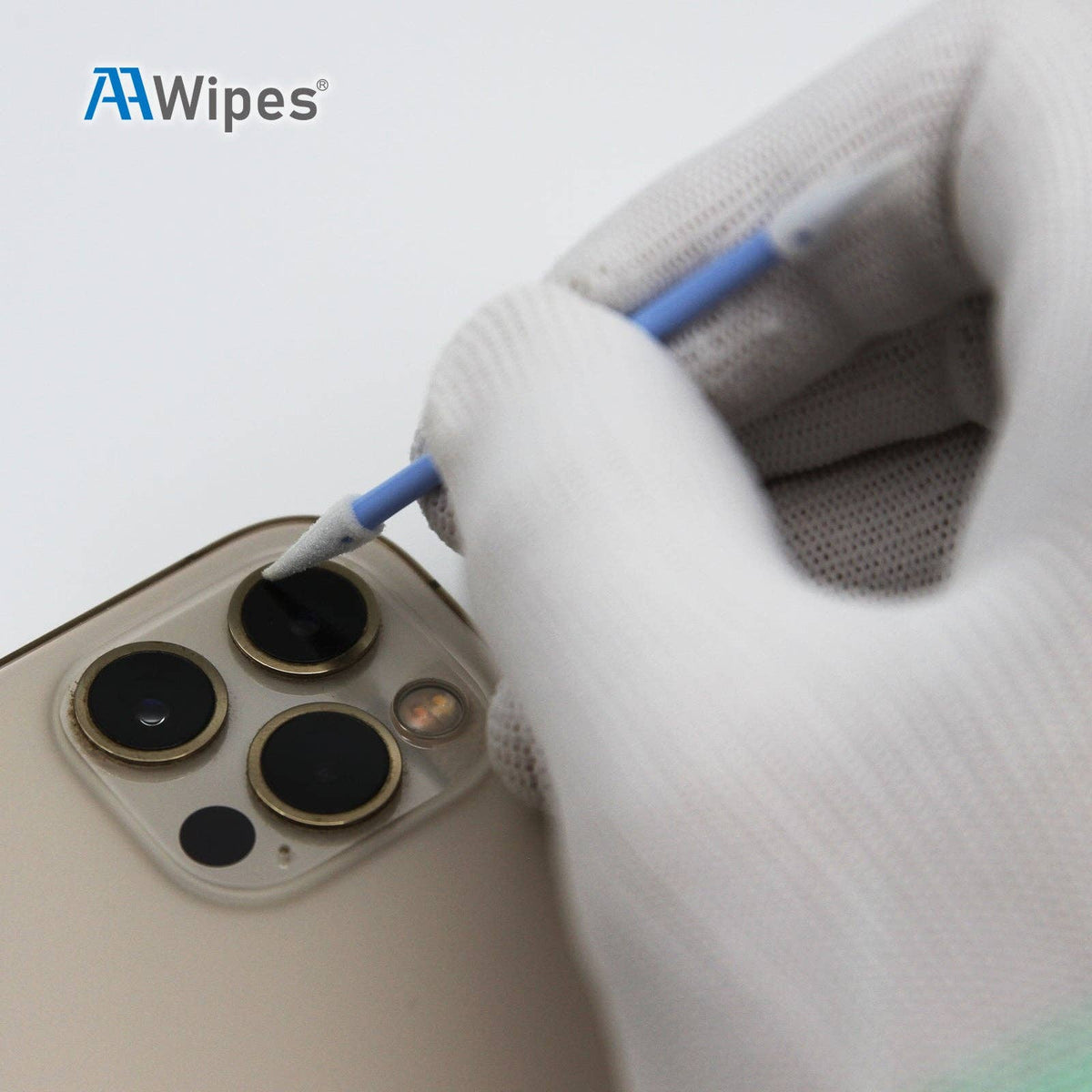 Person cleaning a smartphone camera with a wipe, wearing gloves, on a white background.