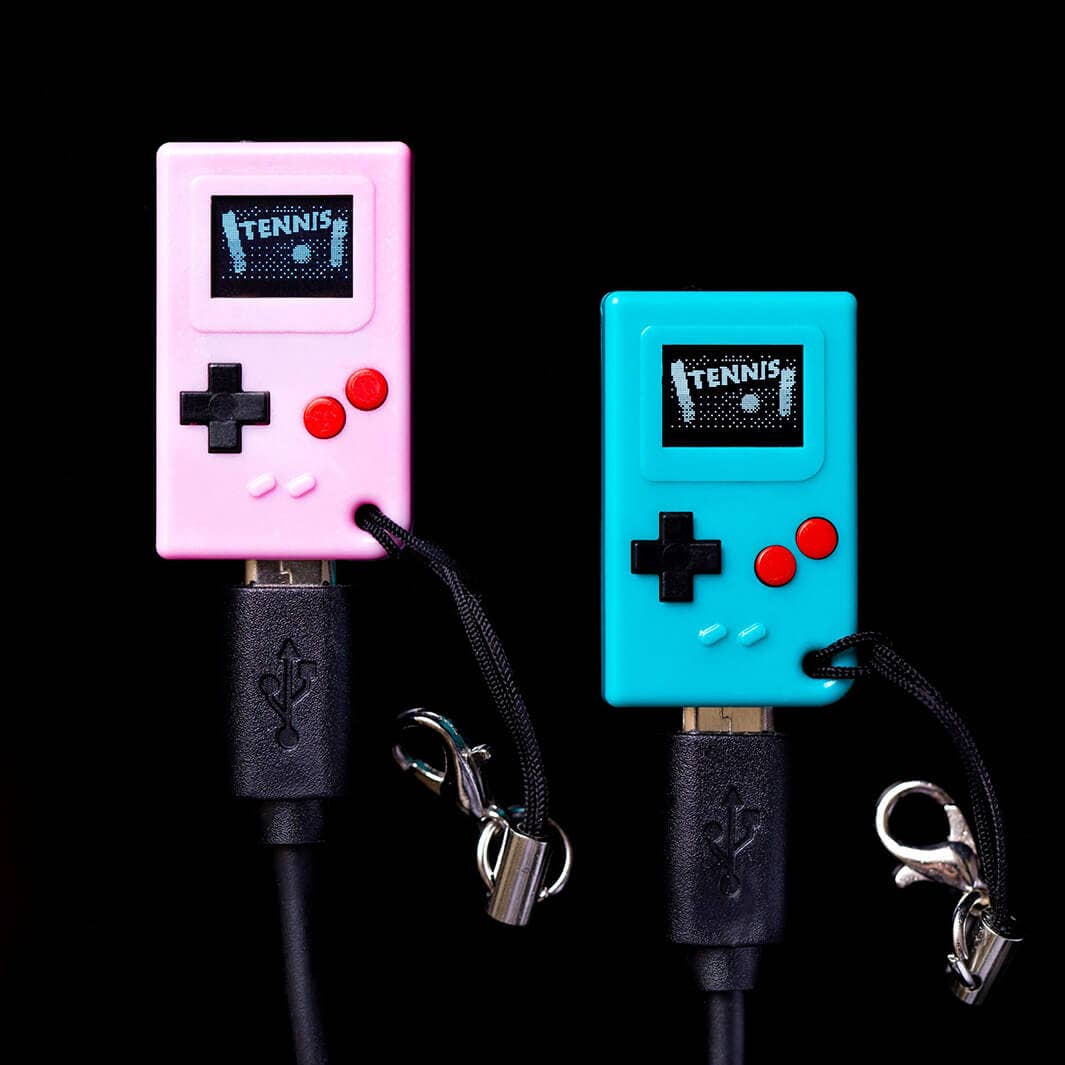 Pink and teal tiny game consoles on a black background