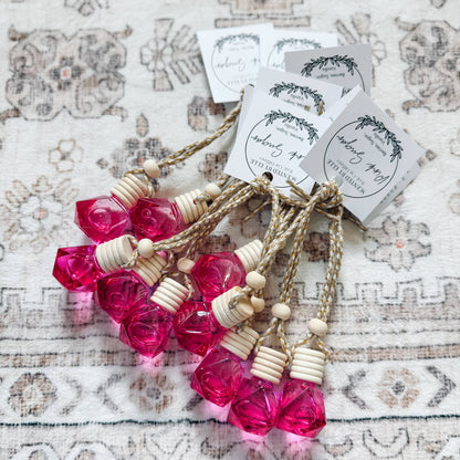 Pink bottles with wooden beads on a textured surface