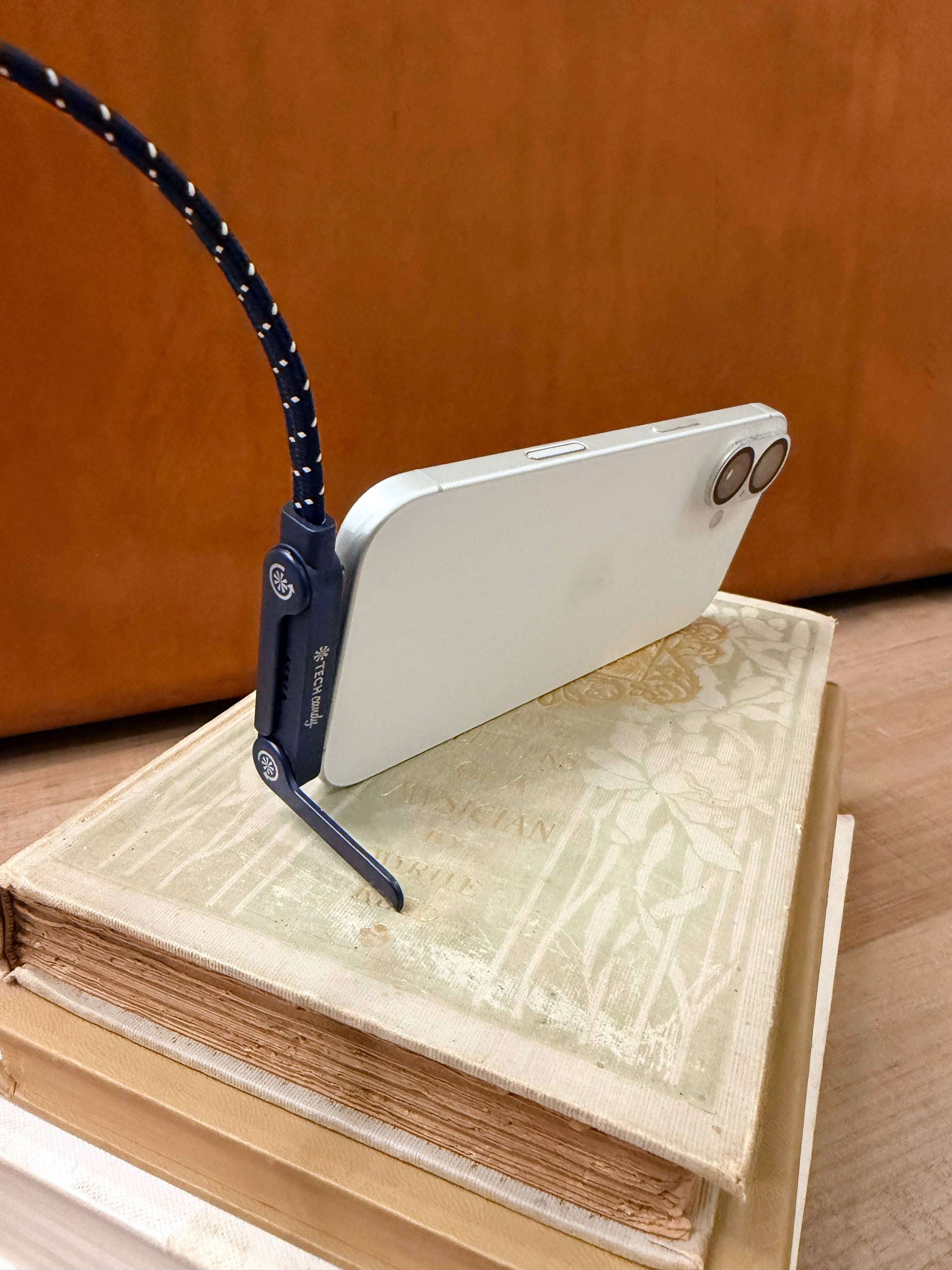 blue and white usb-c charging cable with stand plugged into a phone sitting up in horizontal position