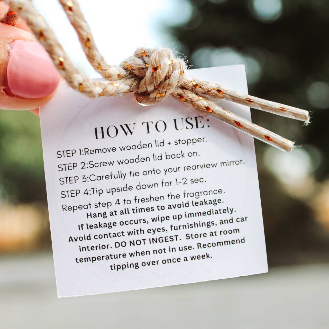 Hand holding a product with a 'How to Use' card against a blurred natural background