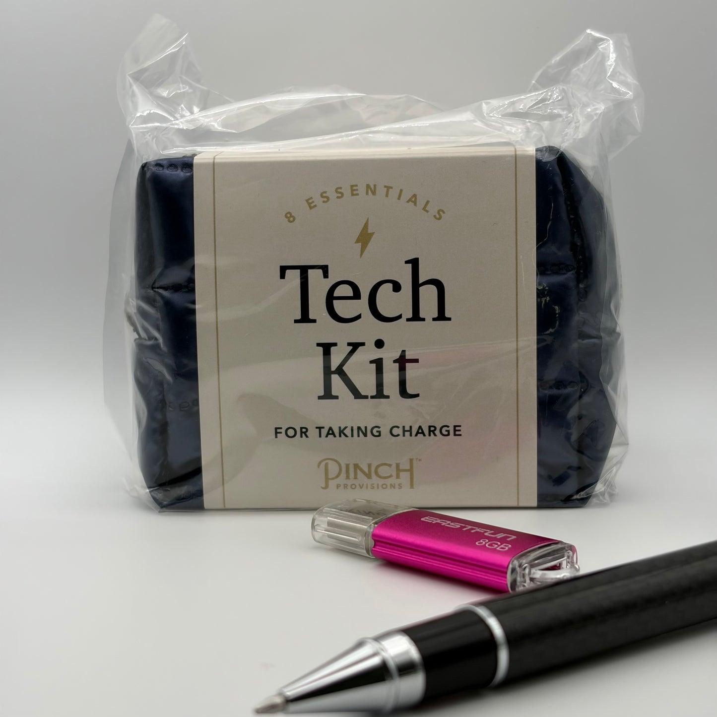 Tech Kit packaging with a pen and USB drive on a white background