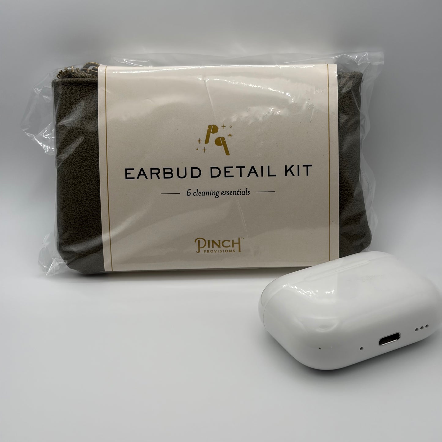 Earbud detail kit with cleaning essentials and a white earbud device on a gray background