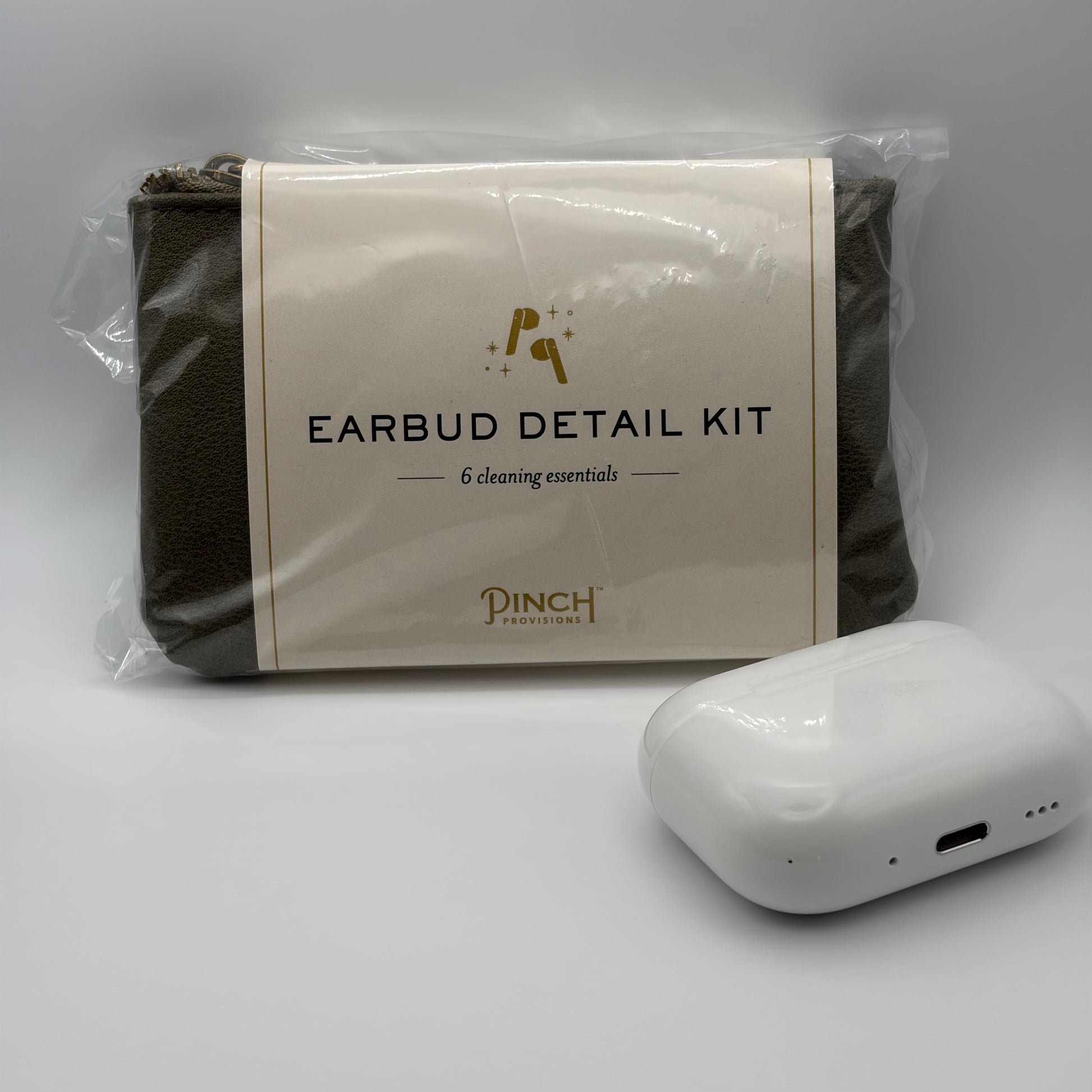 Earbud detail kit with cleaning essentials and a white earbud device on a gray background