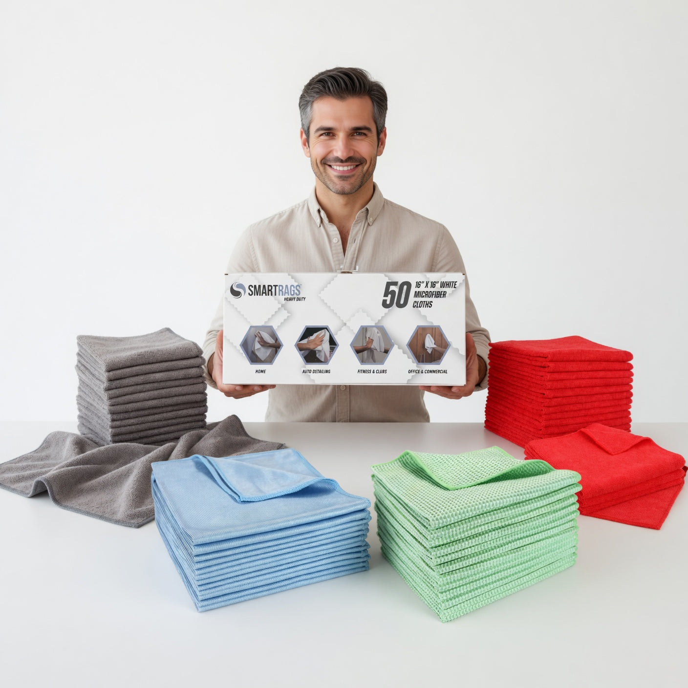 Man holding a box of SMARTBAGS with other colorful cleaning cloths displayed on a table.