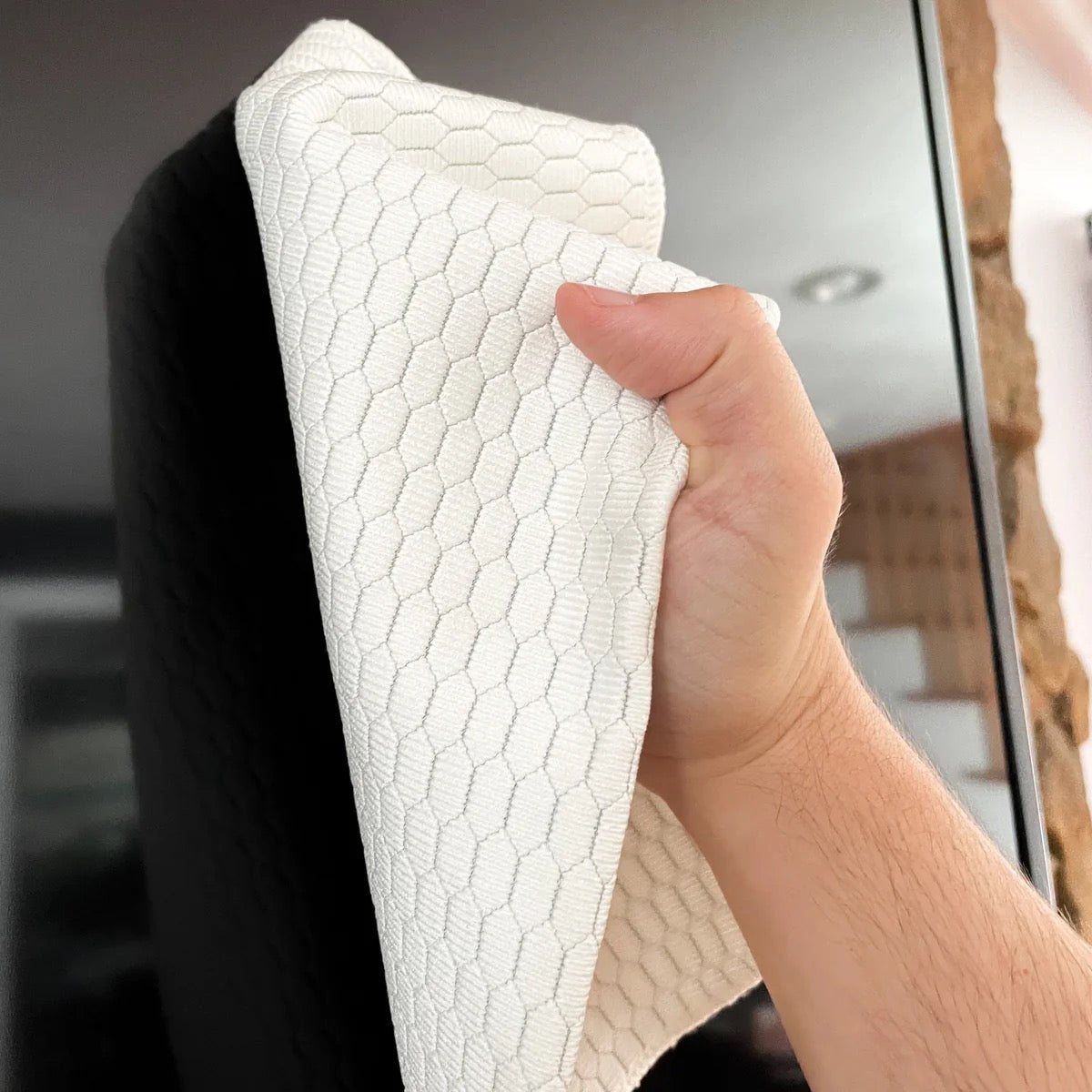 Photo of person using E-Cloth screen cleaning cloth to clean a television screen.