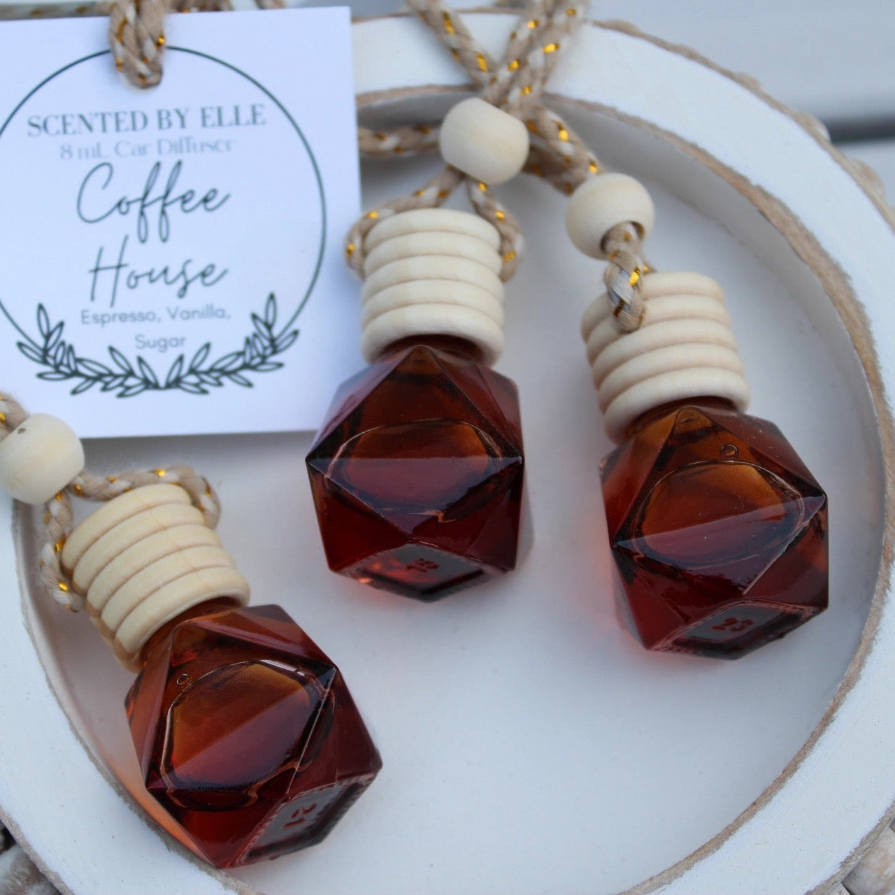 Decorative car diffuser with amber resin stones and beige beads on a white background