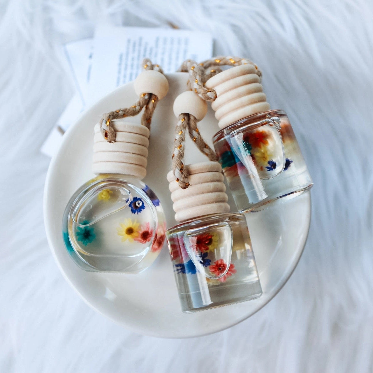 Three small glass bottles with colorful liquids on a white surface