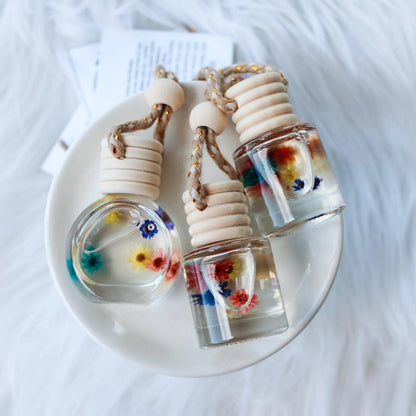 Three small glass bottles with colorful liquids on a white surface