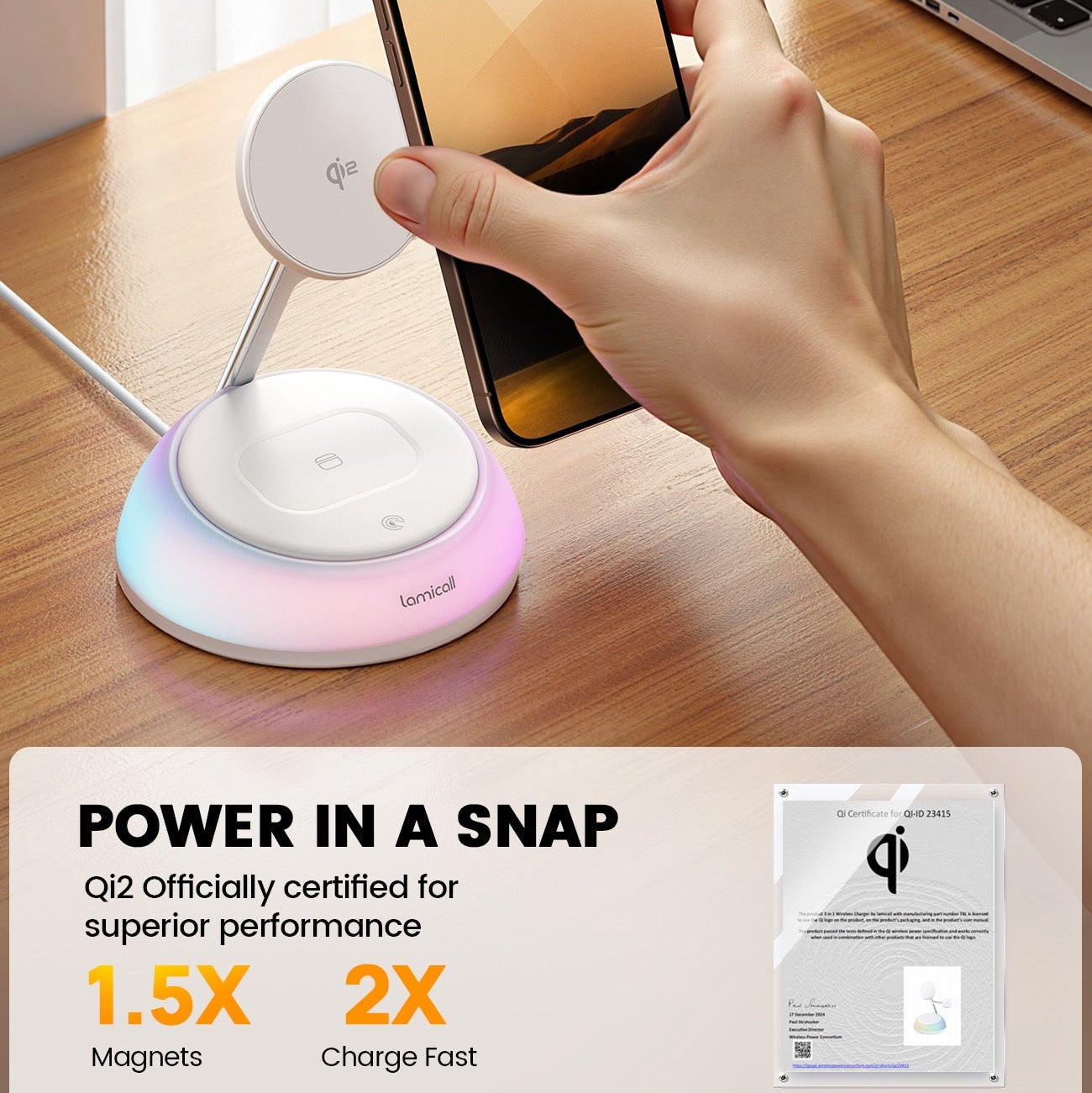 Hand holding a phone above a wireless charging pad with a laptop in the background