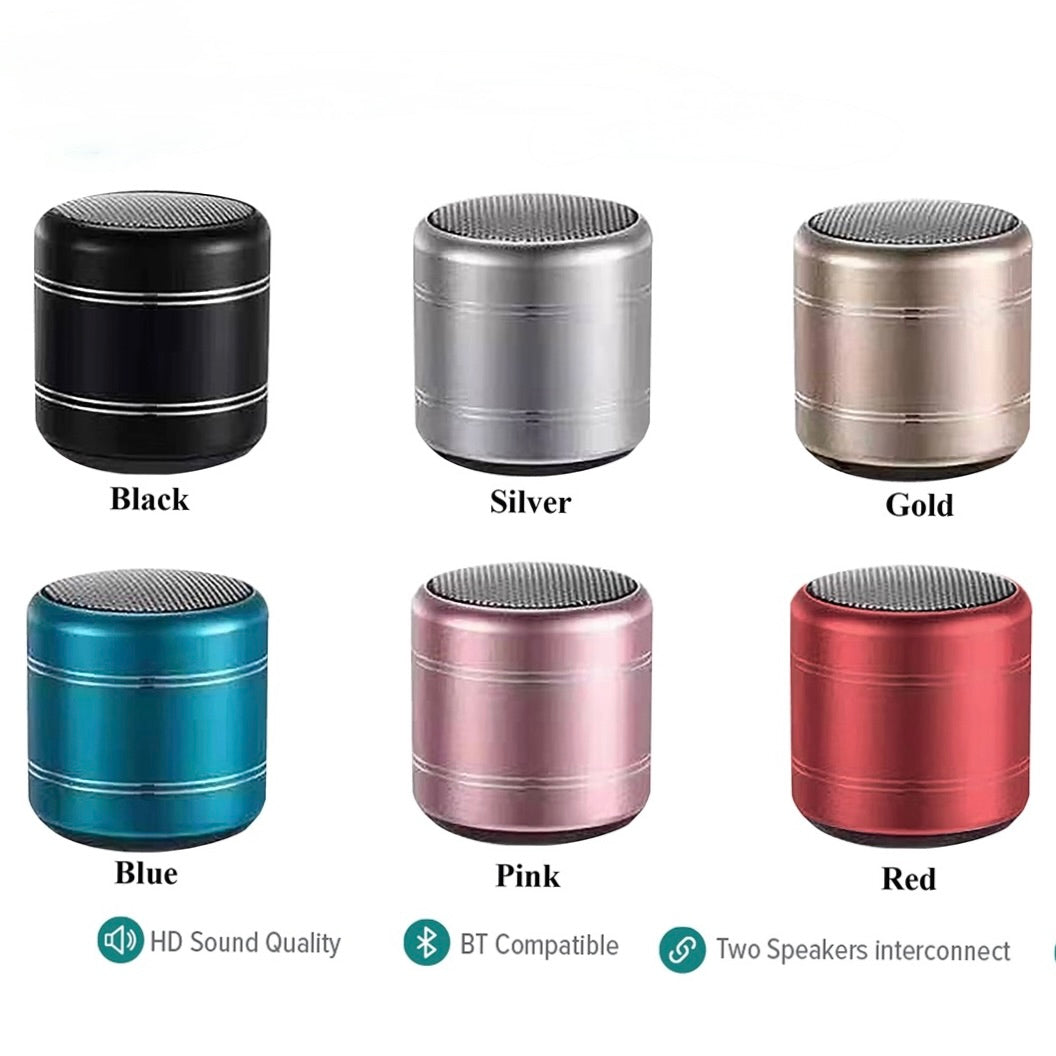 Six cylindrical portable Bluetooth speakers shown in different colors: Black, Silver, Gold, Blue, Pink, and Red. Each speaker is labeled with its color name, and feature icons below indicating HD Sound Quality, BT Compatible, and Two Speakers interconnect.