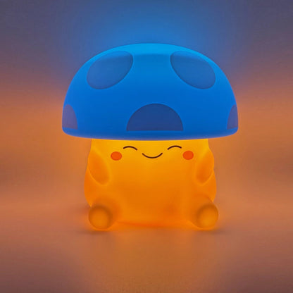 A cute mushroom-shaped glowing night light with a blue cap and a warm orange body, sitting on a soft gradient surface.