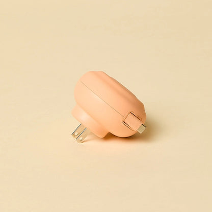 Round peach-colored retractable charger on a beige background