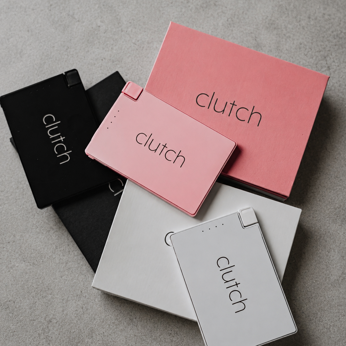 Clutch chargers on a grey background in pink, white, and black