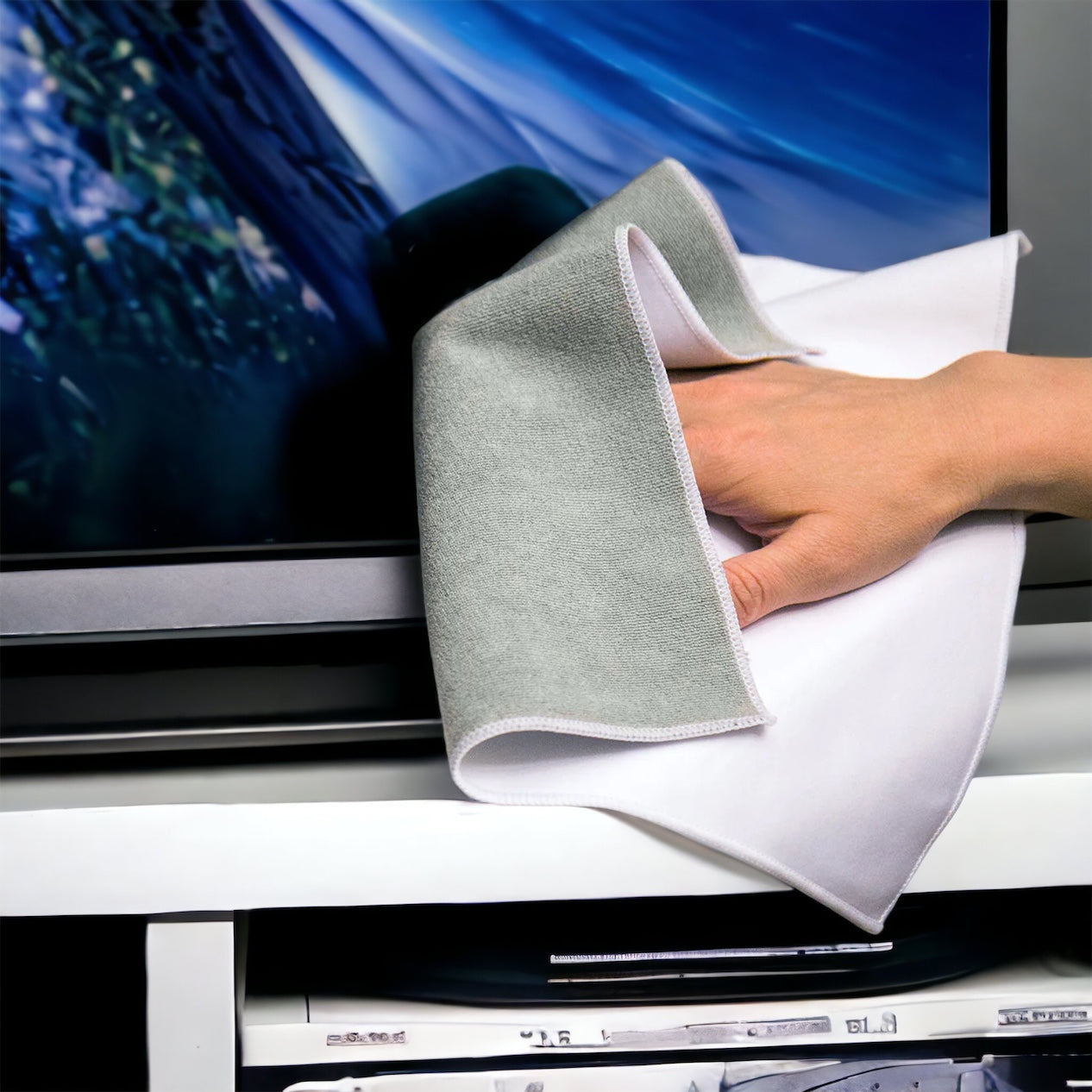 Large multipurpose white and grey microfiber cloth cleaning a television screen.