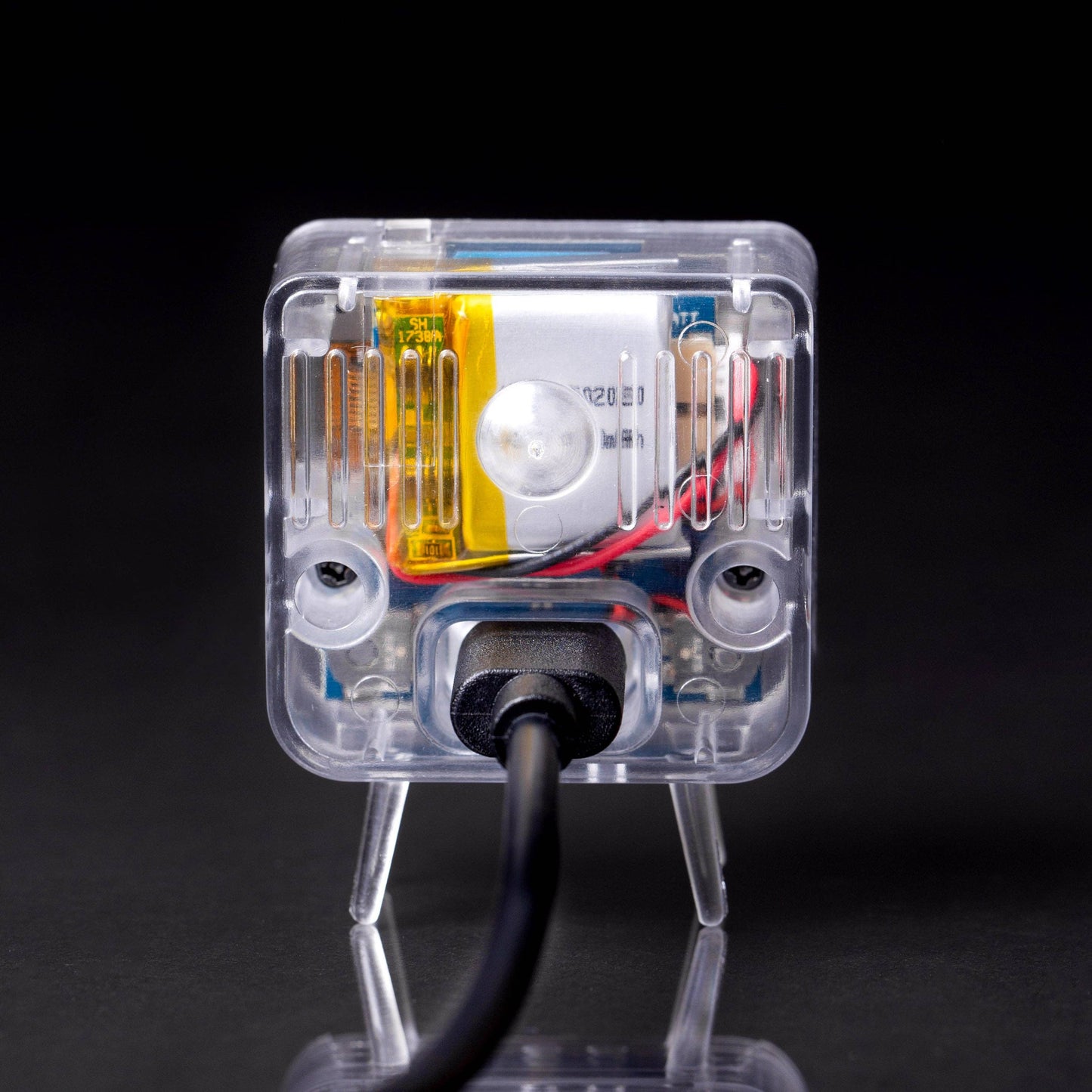 Tiny TV with wires on a black background