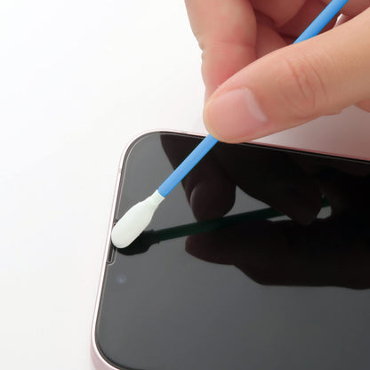 A close-up of a hand using a blue-handled cotton swab to clean the edge of a black smartphone screen.