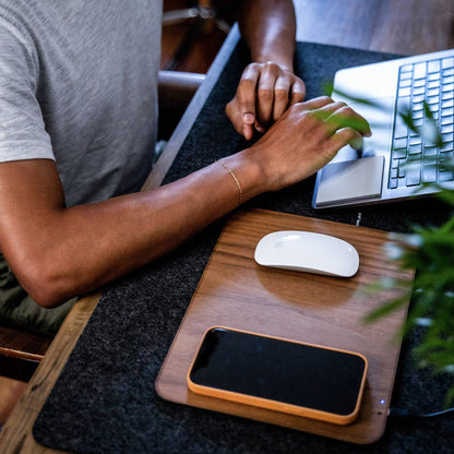 WUDN large real wood wireless charging mouse pad with built-in 15W Qi fast charger, shown with a mouse and iPhone next to a guy using a laptop.