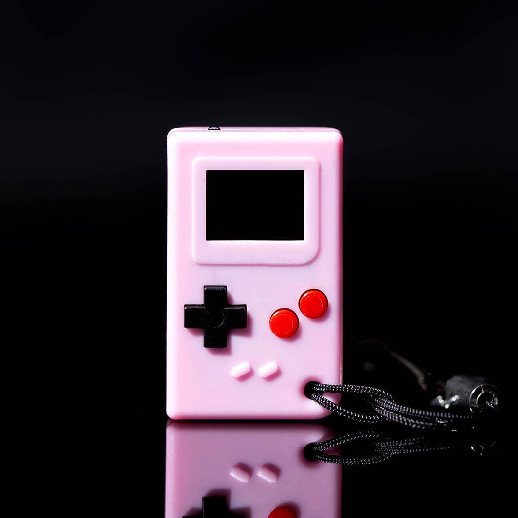 Pink handheld gaming console with black and red buttons on a black background