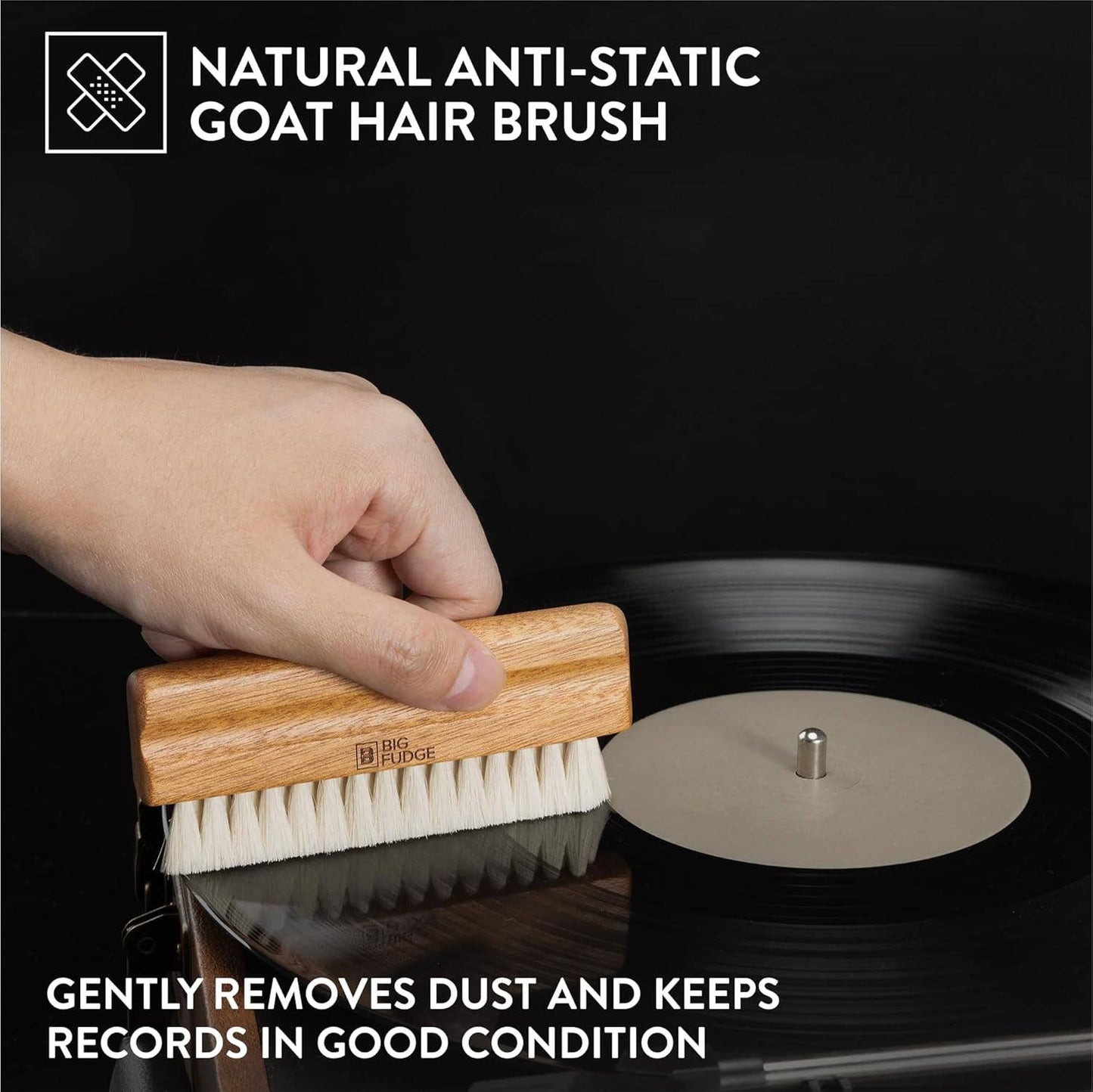Hand using a natural anti-static goat hair brush on a vinyl record with text about its use.