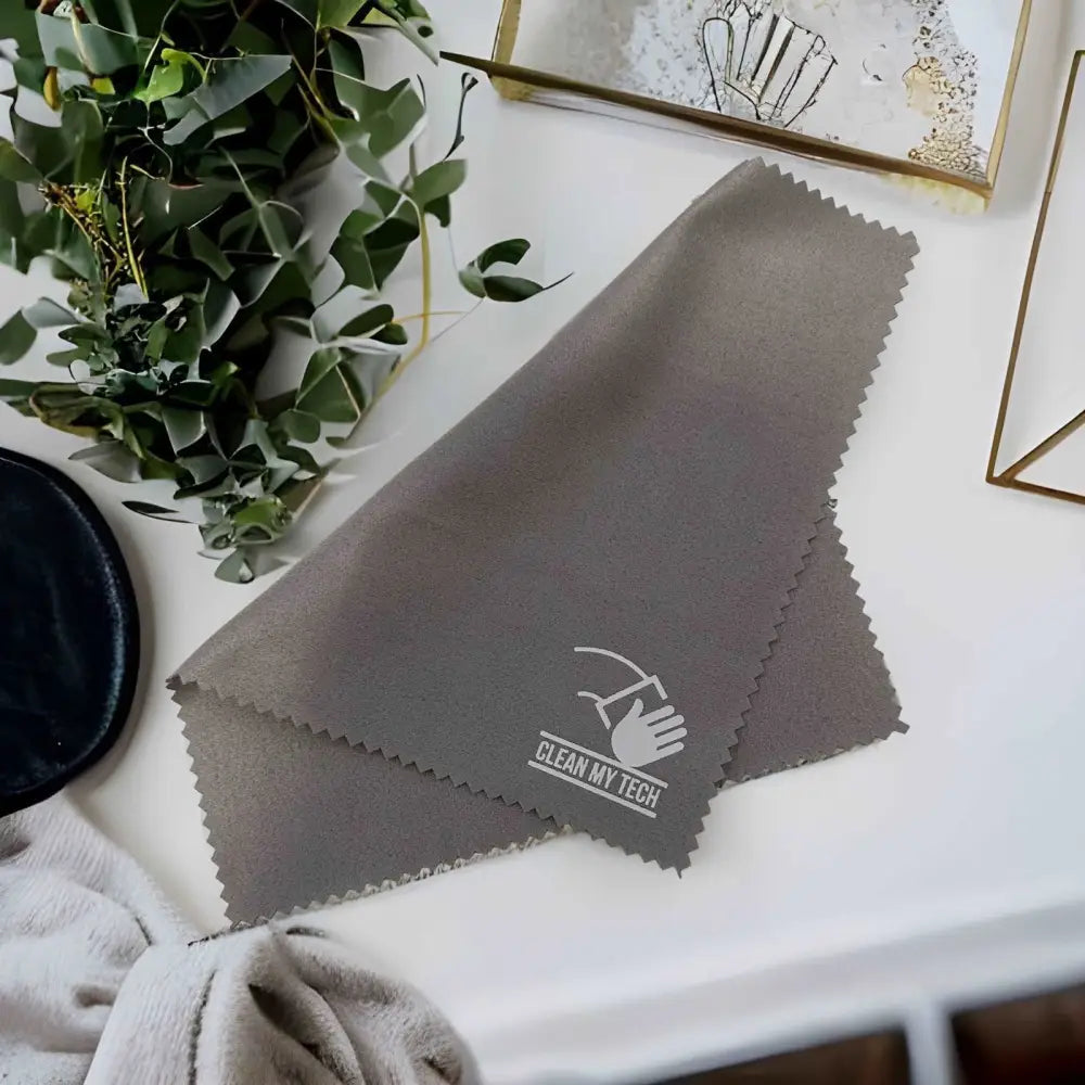 Gray microfiber cleaning cloth with a white ’clean my tech’ logo and serrated edges.
