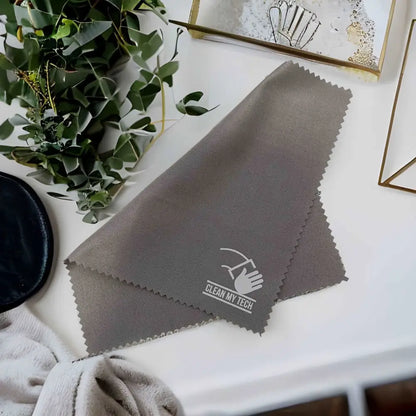 Gray microfiber cleaning cloth with a white ’clean my tech’ logo and serrated edges.