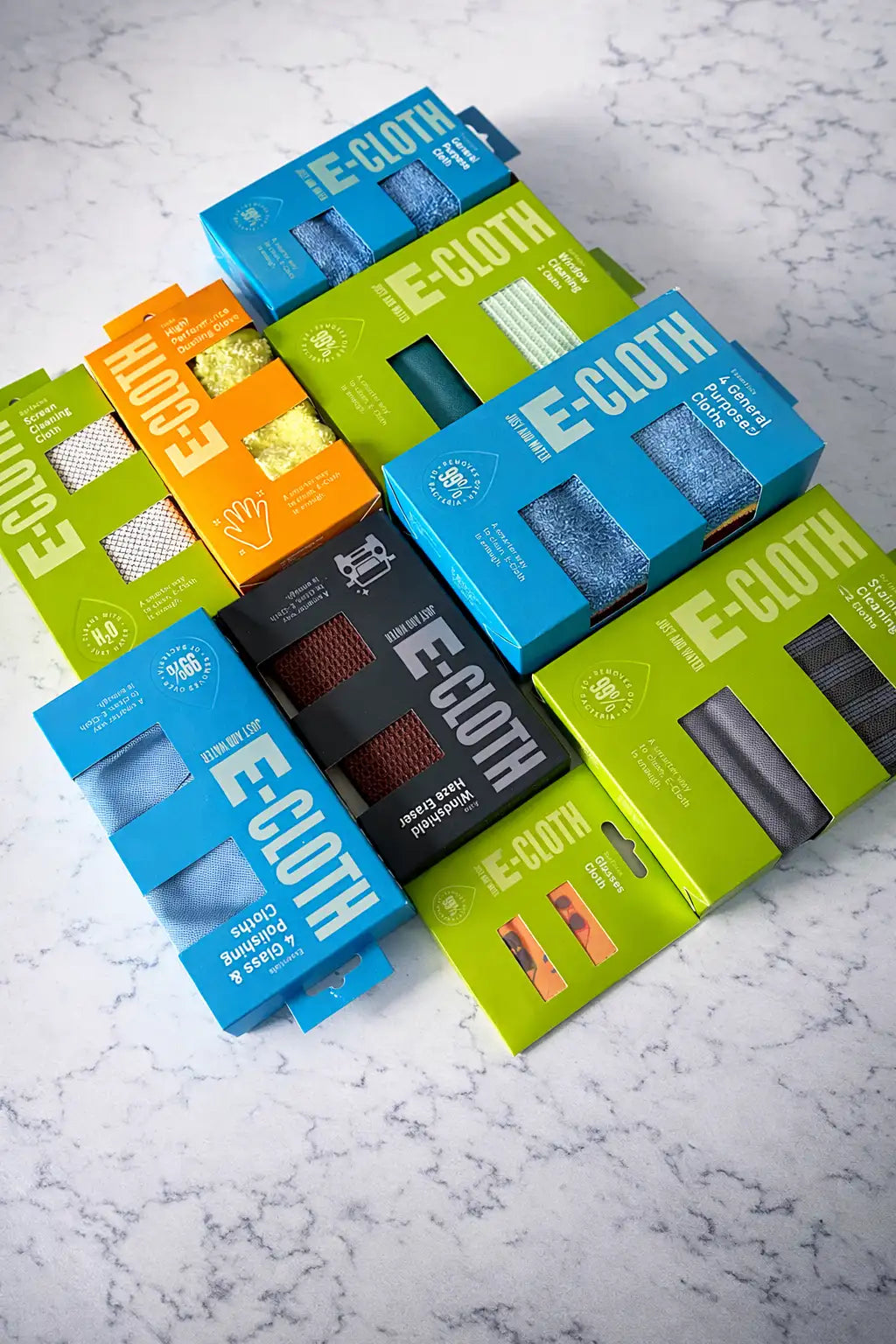 Colorful e-cloth microfiber cleaning cloths in vibrant blue, green, orange, and black packaging.