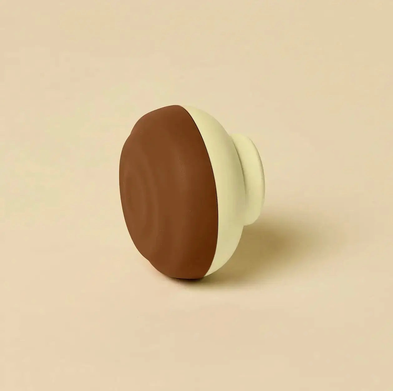 Brown and cream two-tone silicone door knob cover compatible with counterpart usb-c retractable charger wall charger accessory