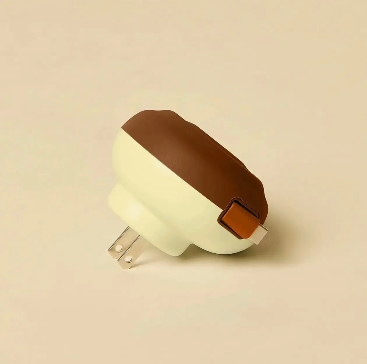 Cream-colored and brown silicone usb c wall charger nightlight shaped like a chocolate-covered donut with orange switch