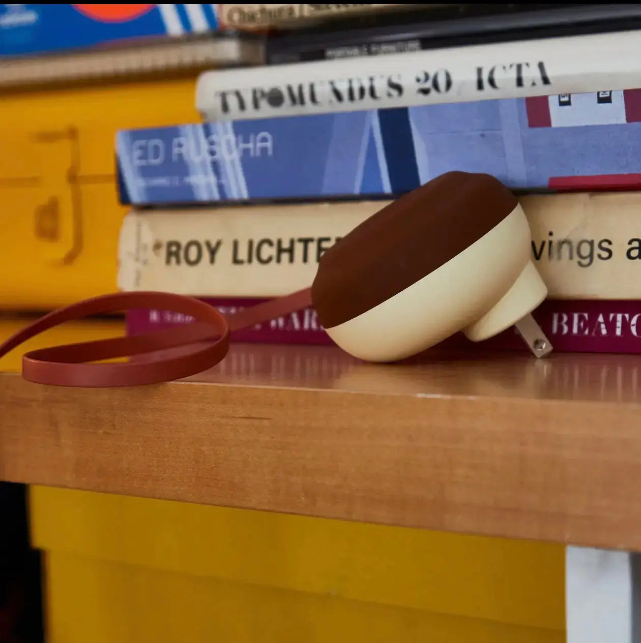 Cream and brown two-tone silicone usb-c cord charging pad with matching reddish-brown strap for wall charger organization