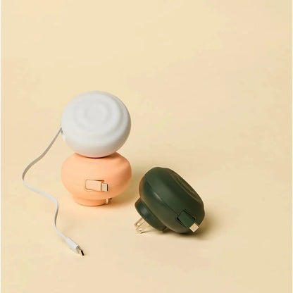 Pastel-colored, compact portable power banks with rounded plastic bodies and integrated usb-c cables.