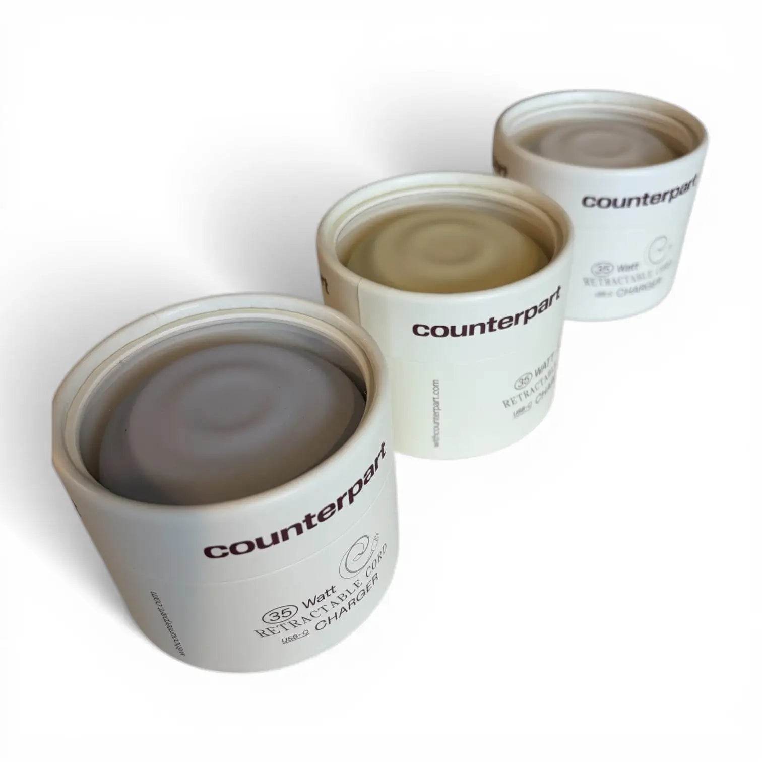 White cylindrical countertop charger with a matte finish and minimalist branding.