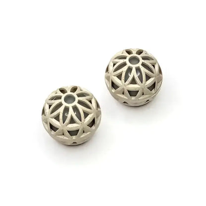 Silver-toned spherical beads with intricate geometric cutouts.