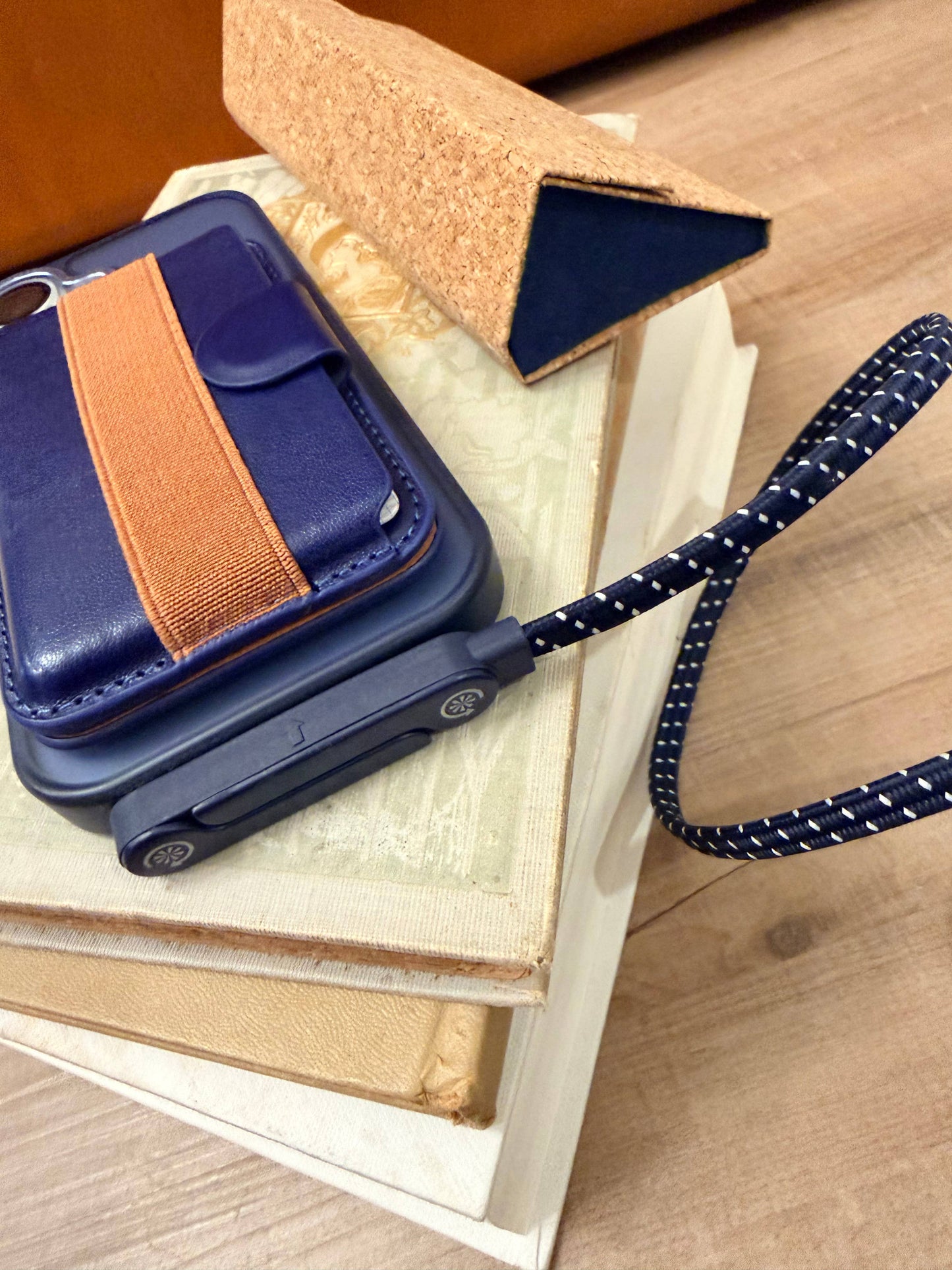 blue and white usb-c charging cable plugged into a phone laying on a stack of books