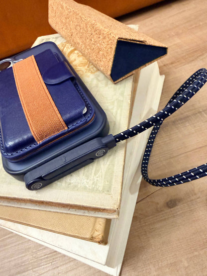 blue and white usb-c charging cable plugged into a phone laying on a stack of books