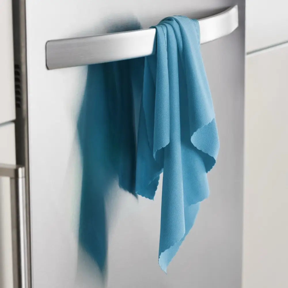 A teal microfiber cleaning cloth draped over a sleek silver refrigerator handle.