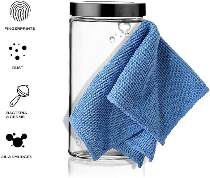 A clear glass jar with a black lid, shown with a blue microfiber cloth draped over the side. On the left, black icons and text list cleaning claims such as fingerprints, dust, bacteria & germs, and oil & smudges on a white background.