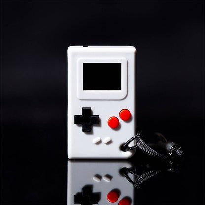 White handheld gaming console with red and black buttons on a reflective surface with a dark background