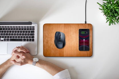 WUDN large real wood wireless charging mouse pad with built-in 15W Qi fast charger, shown with a mouse and iPhone on a white table with a man in front of his laptop computer