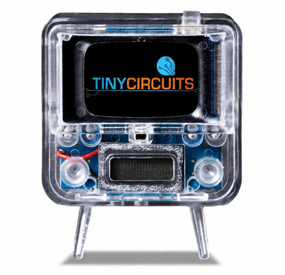 A small electronic circuit kit in a transparent protective case with two legs, featuring a black front panel with the 'TINYCIRCUITS' logo and visible blue internal components.