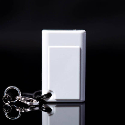 The back of the gray tiny game console on a black background with a keychain attached. 