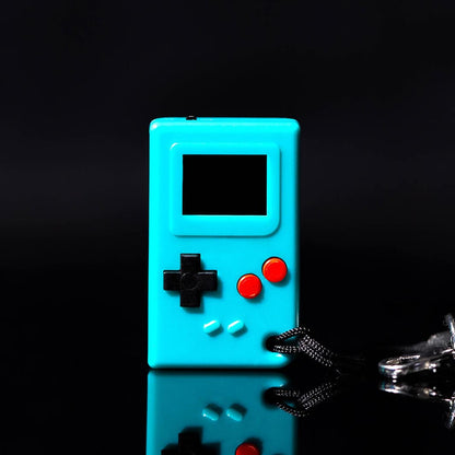Teal handheld game console with black and red buttons on a reflective surface.