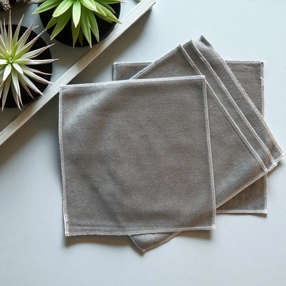 Gray microfiber cleaning cloths with neatly stitched edges.