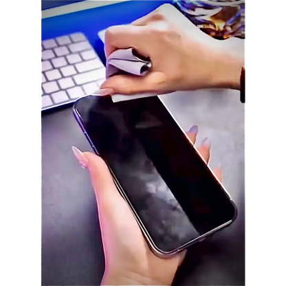 A sleek black smartphone with a glossy finish, held securely in one hand while being wiped down by the other.