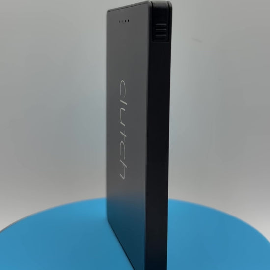 black Clutch Pro USB-C power bank rotating on a blue pedestal 