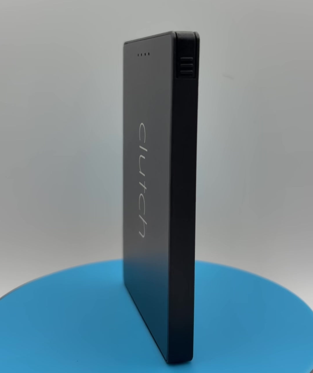 black Clutch Pro USB-C power bank rotating on a blue pedestal 